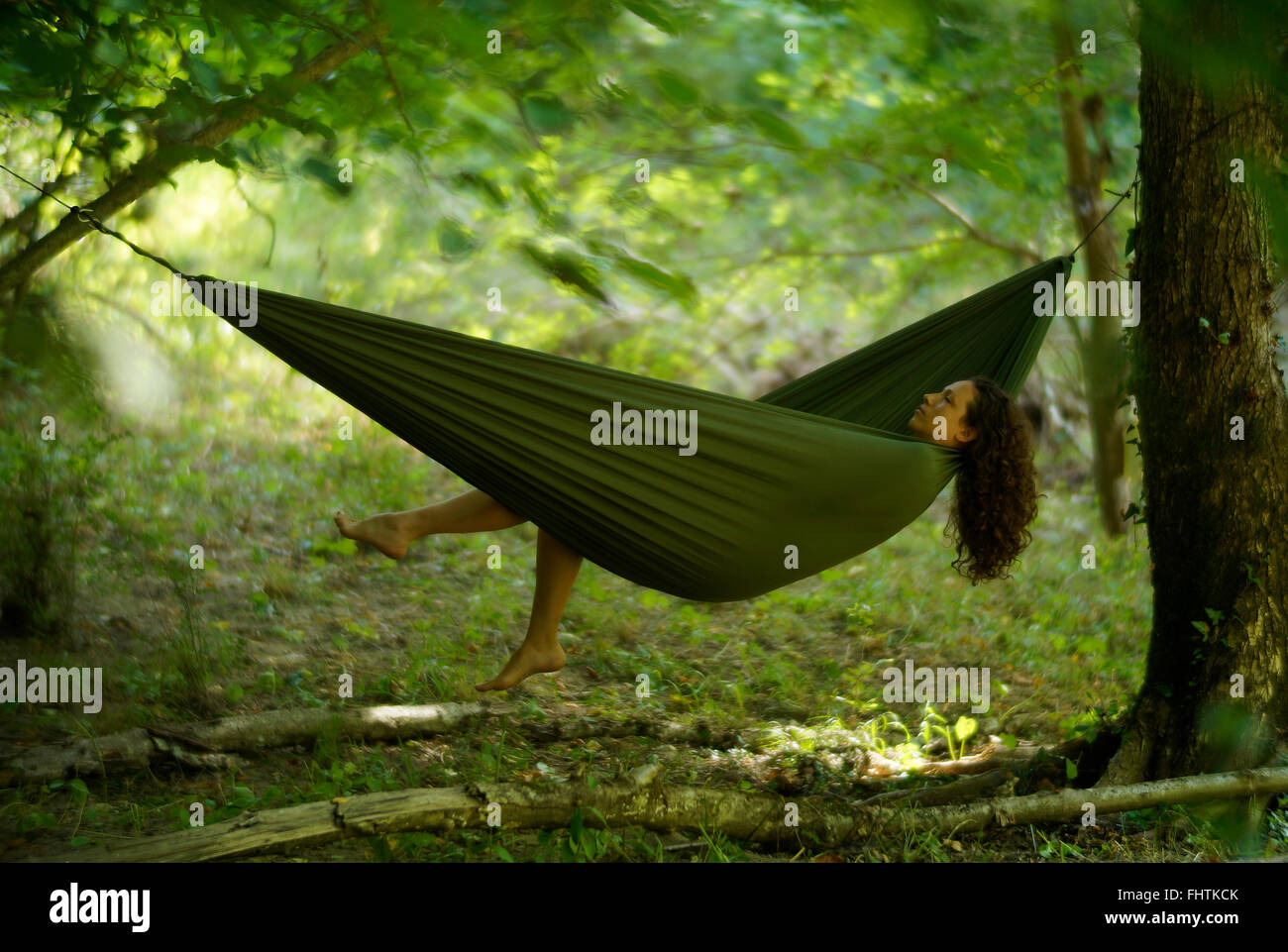 Beautiful young woman relaxing in a hammock deep in the woods Stock ...