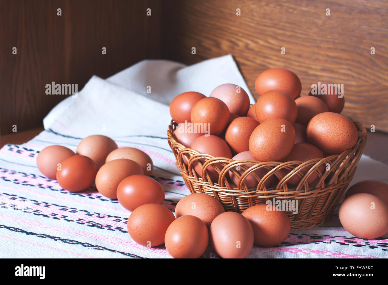 Heap of raw fresh chicken eggs in a wooven basket. Food stock image Stock Photo