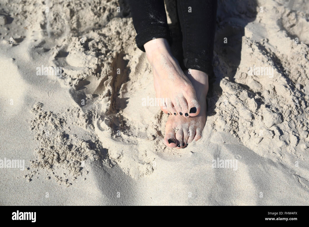 woman's foot. Relax on the beach. Beach holiday. Feet of a woman buried ...