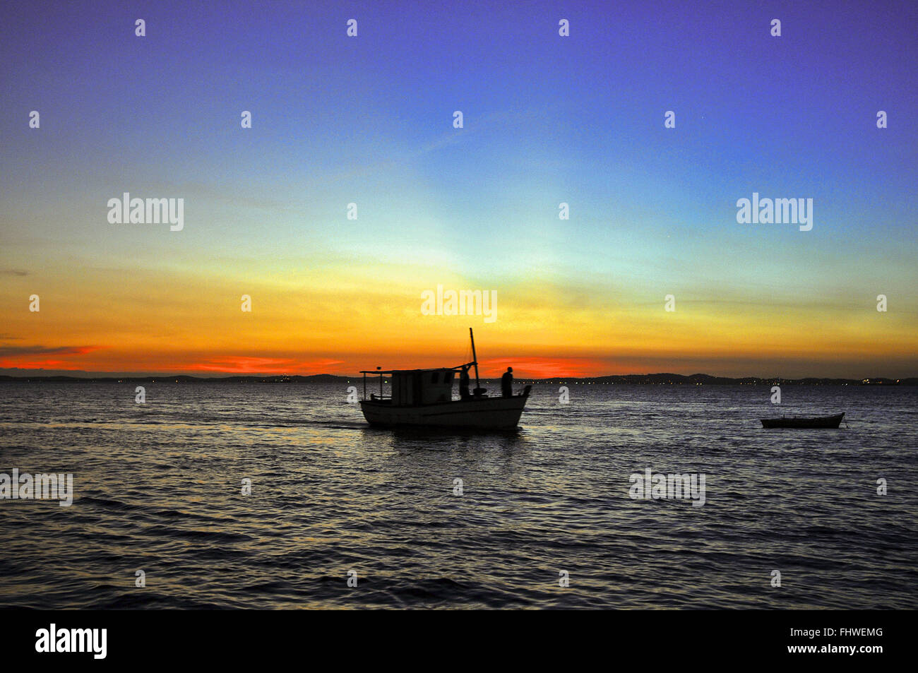 Landscape with sunset and fishing boat on the beach Porto da Barra Stock Photo