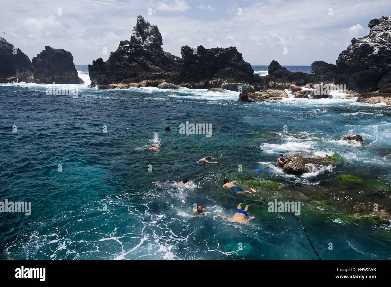 Researchers swimming in front of the railway in the Brazilian Scientific Belmonte Island Stock Photo
