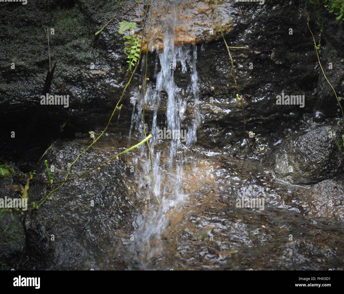 Small waterfall flowing over rocks Stock Photo - Alamy