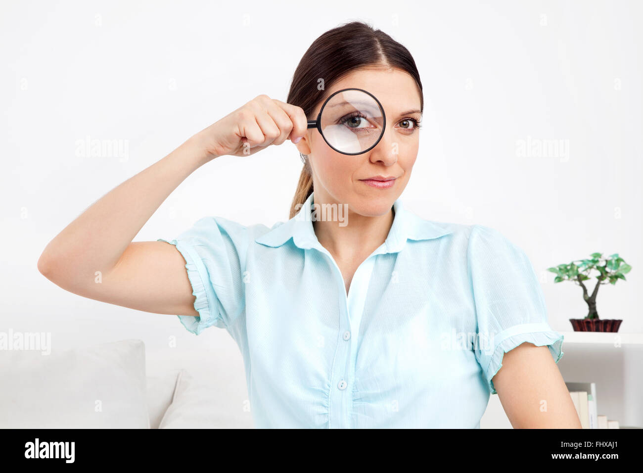 Elderly woman looking through magnifying glass with her eye Stock Photo ...