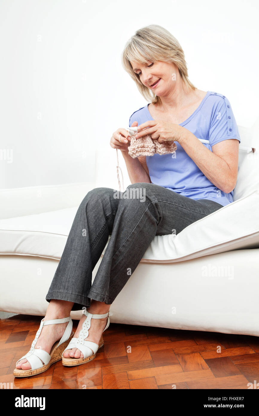 Happy senior woman knitting at home in living room Stock Photo - Alamy