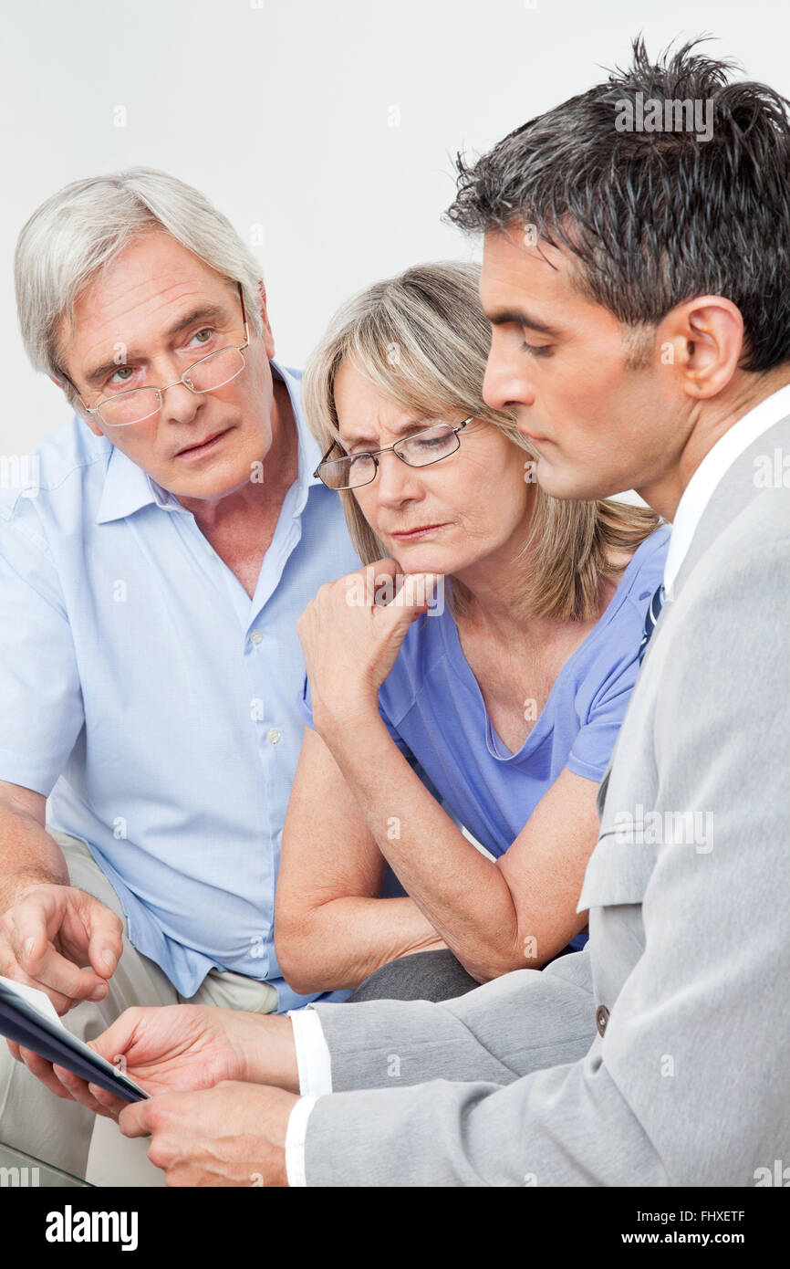 Financial advisor talking to senior couple at home Stock Photo