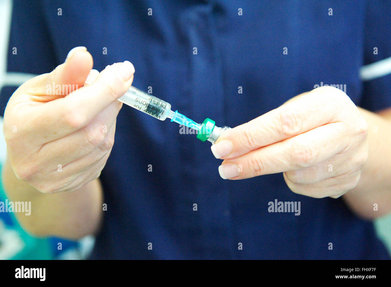 Nurse prepares MMR vaccine at GP health centre Stock Photo