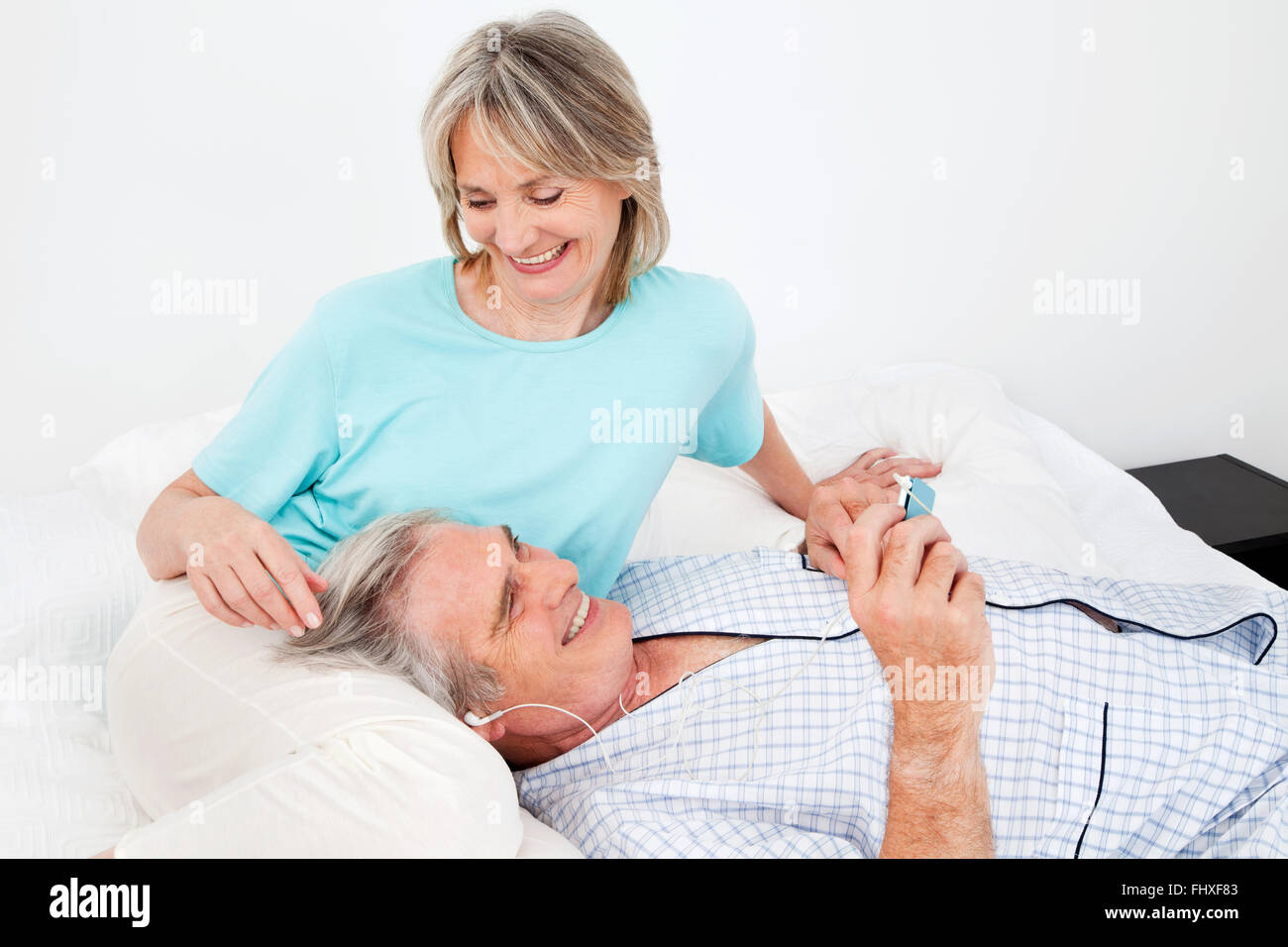 Happy senior man listening to music with headphones and small player Stock Photo