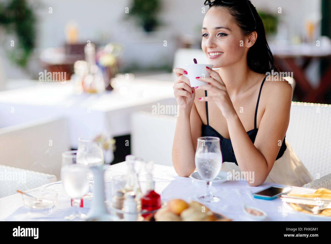 Beautiful woman drinking tea in restaurant while waiting for her meal