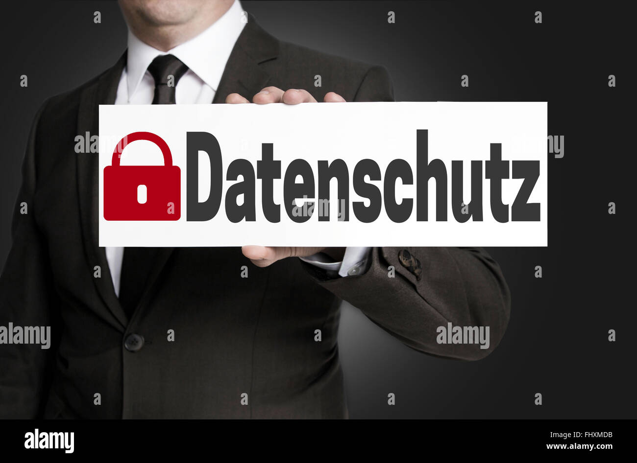data protection (in german datenschutz) placard is held by businessman. Stock Photo