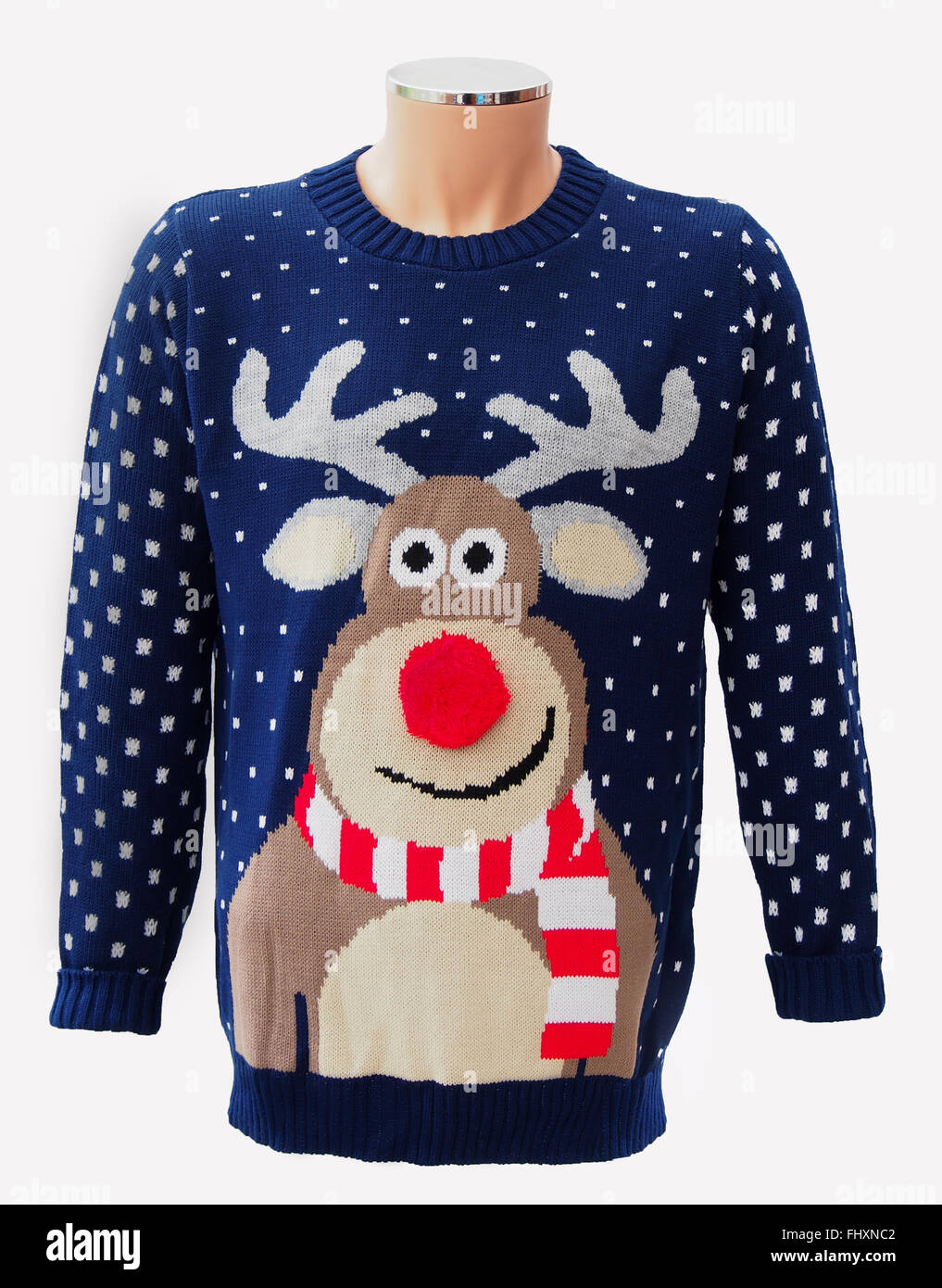 Blue knitted adults' Christmas jumper, featuring Rudolph the red nosed reindeer and snowflakes, isolated on a white background. Stock Photo