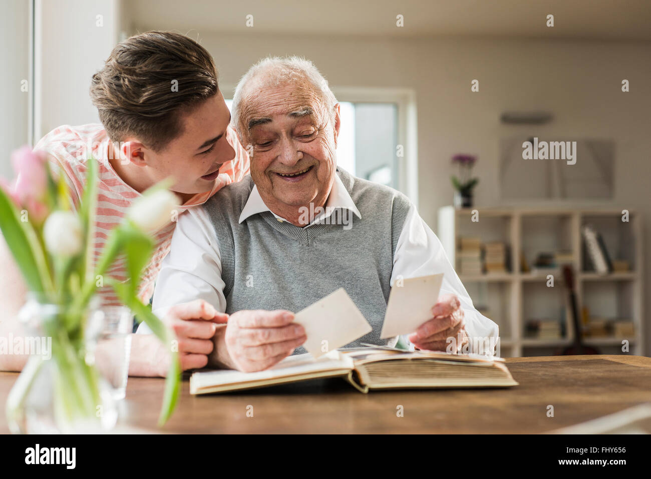 Grandfather and grandson watching old photographies together Stock Photo