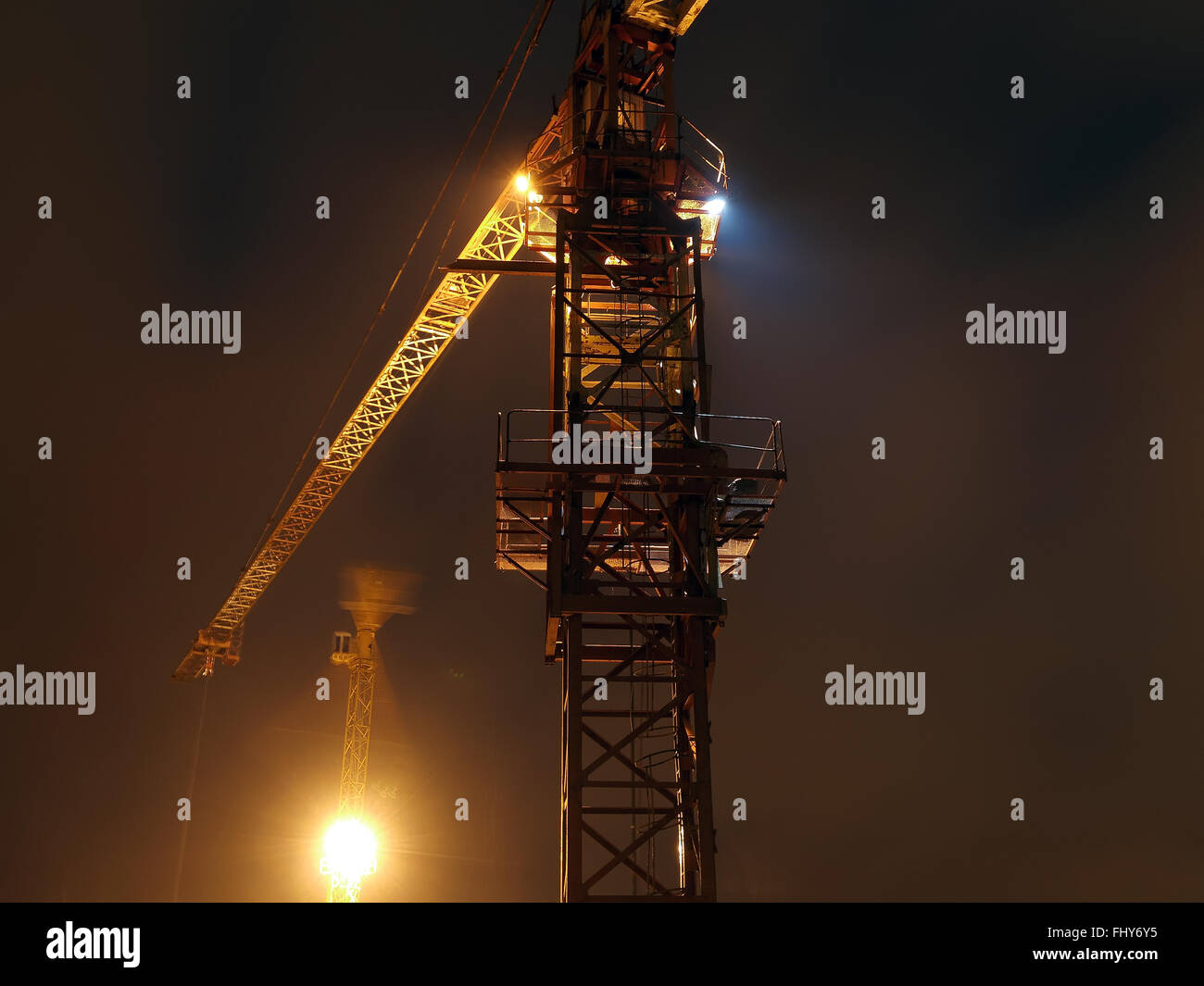 construction site with cranes and illumination at night, long exposure ...