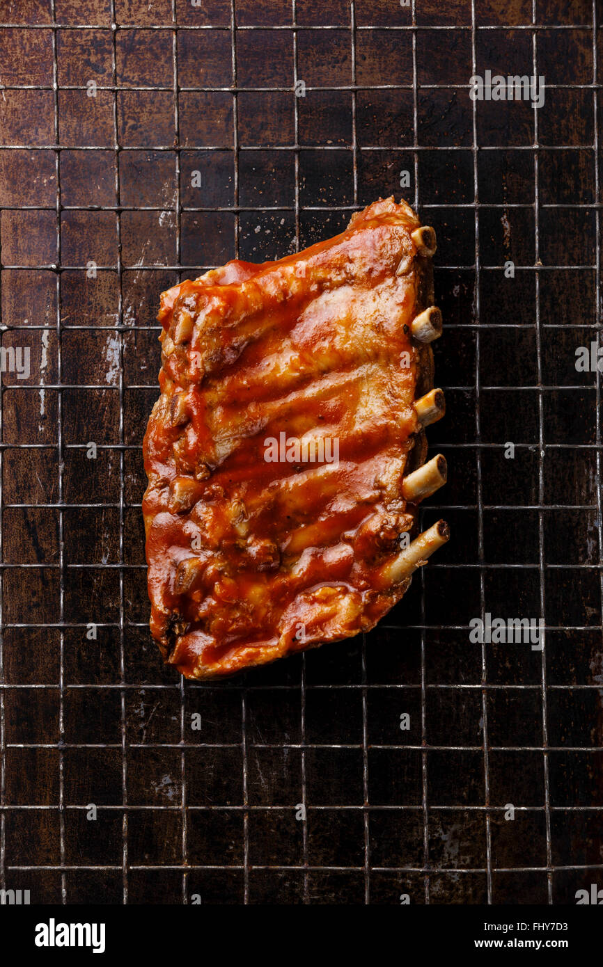 BBQ grilled smoked pork ribs on dark metal baking sheet background Stock Photo