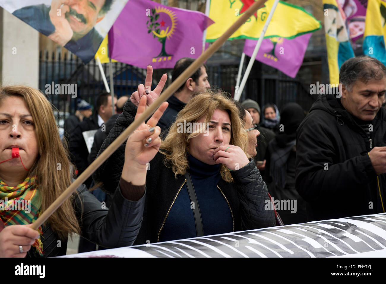 Two women whistling and flashing peace signs during the Kurdish