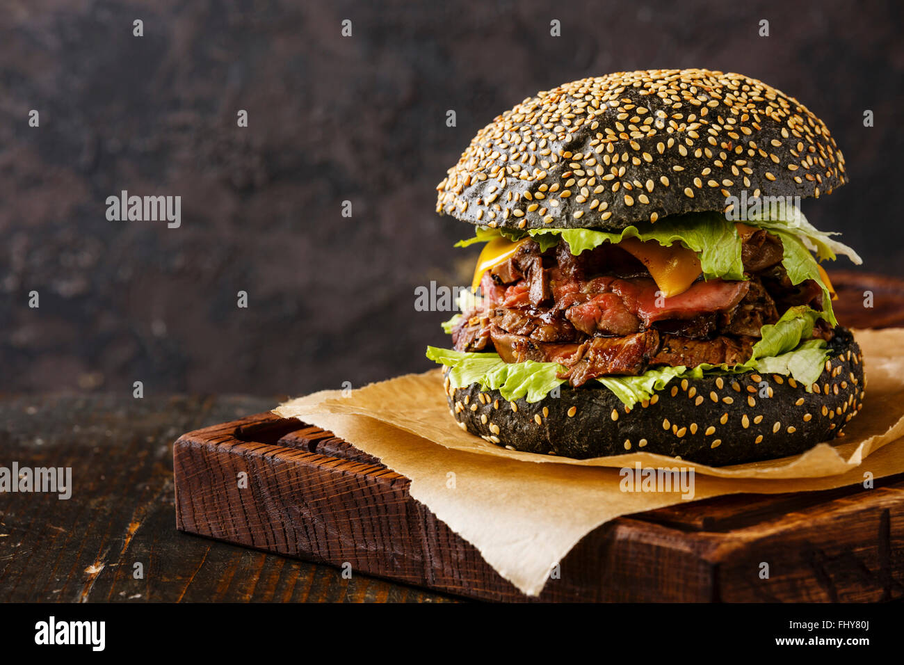 Roast beef Burger on sesame bun with sliced Pastrami on black background Stock Photo