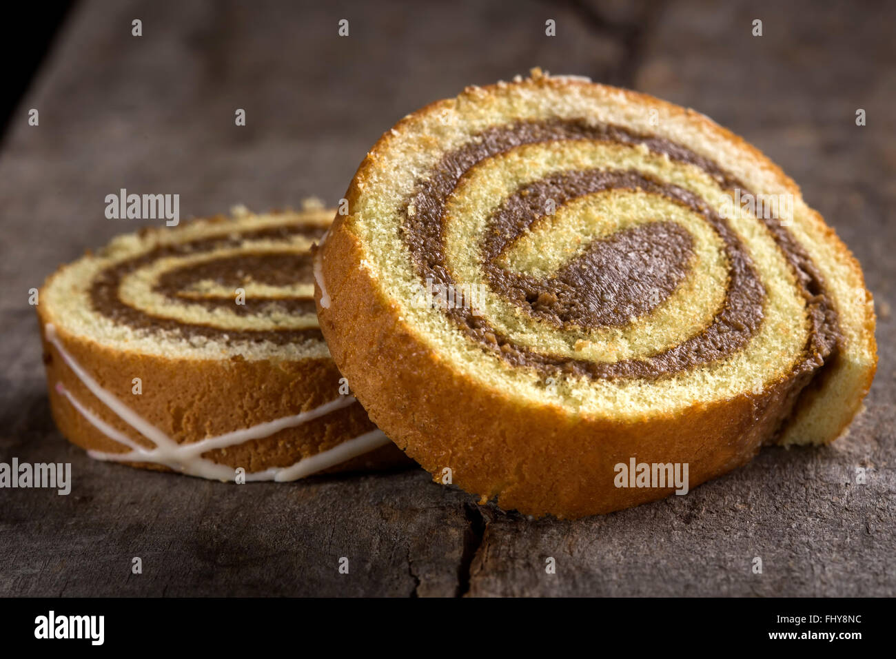 Slices of sponge cake roll over wooden background Stock Photo