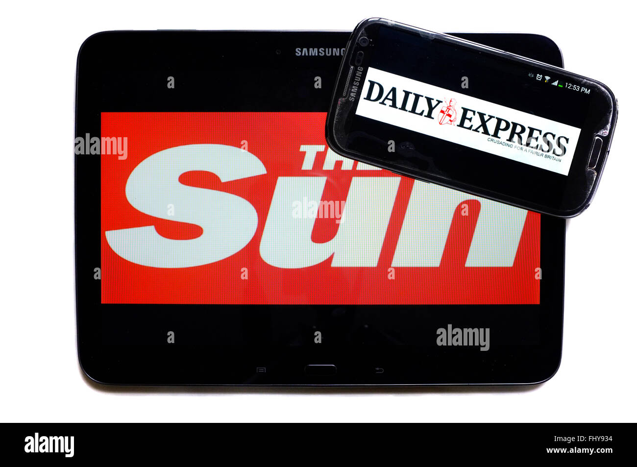 The logos of The Sun and the Daily Express newspapers displayed on the screens of a tablet and a smartphone. Stock Photo