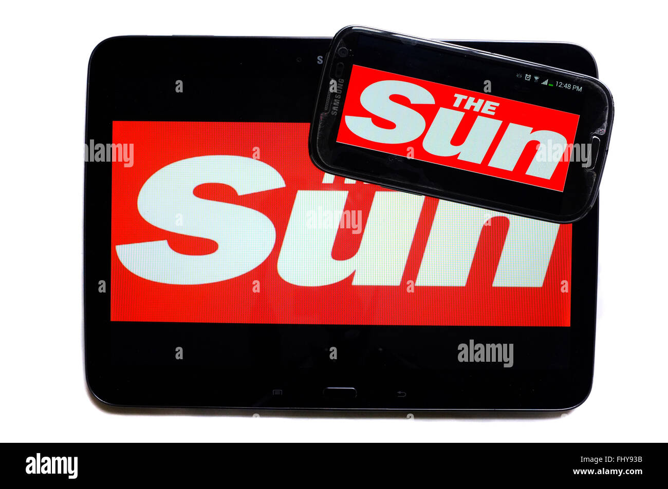 The logo of The Sun newspaper displayed on the screens of a tablet and a smartphone. Stock Photo