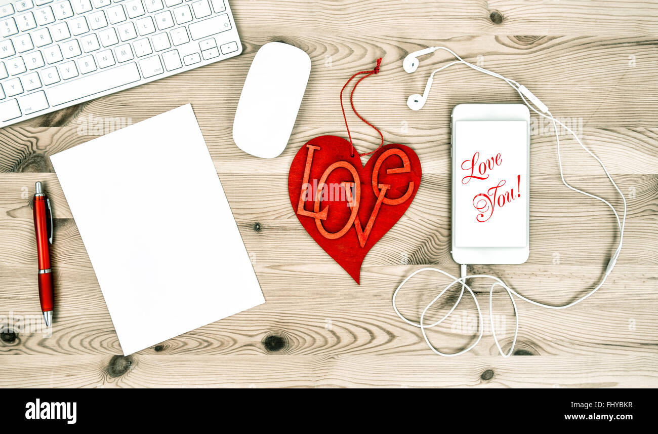 Valentines Day Office Desk with Red Heart and Mobile Phone. Sample text Love You! Stock Photo