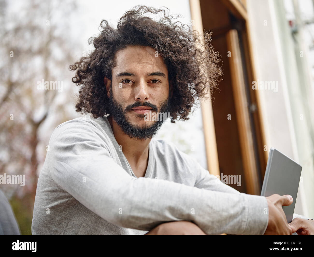 Portrait of young man with digital tablet outdoors Stock Photo