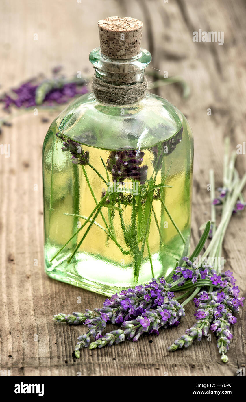 Lavender oil with fresh flowers on wooden background. Apothecary herbs. selective focus Stock Photo