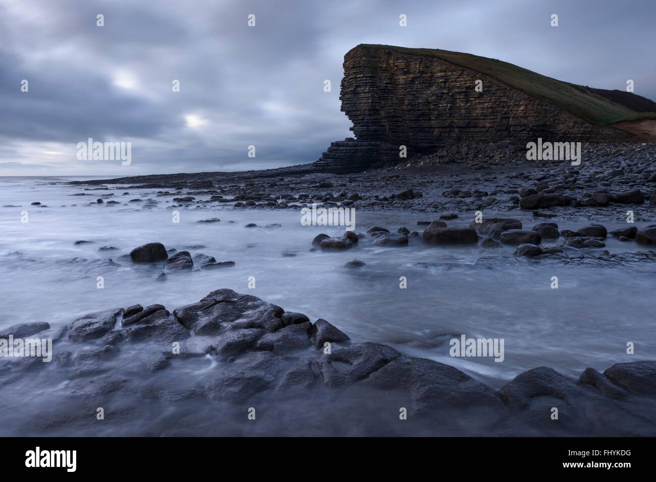 The retreating tide reveals cracked limestone rocks at Nash Point, Glamorgan, Wales. Stock Photo