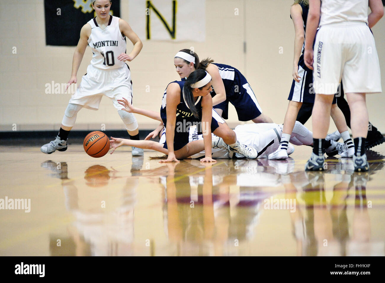 Players scramble for possession of a loose ball during a high school playoff game. USA. Stock Photo
