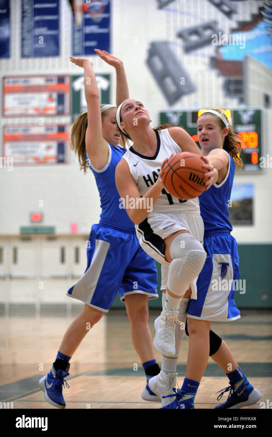 High school player attempting a shot from in the paint after negotiating between a pair of defenders. USA. Stock Photo