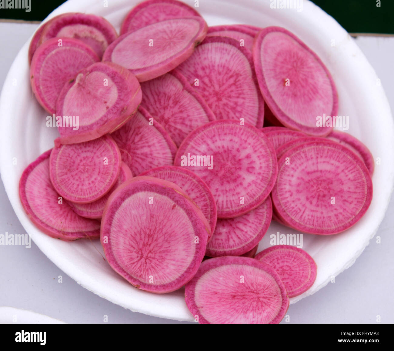 Raphanus sativus, PUSA Gulabi radish, sliced, cultivar with long rose coloured roots, commonly used in salads, vegetable crop Stock Photo