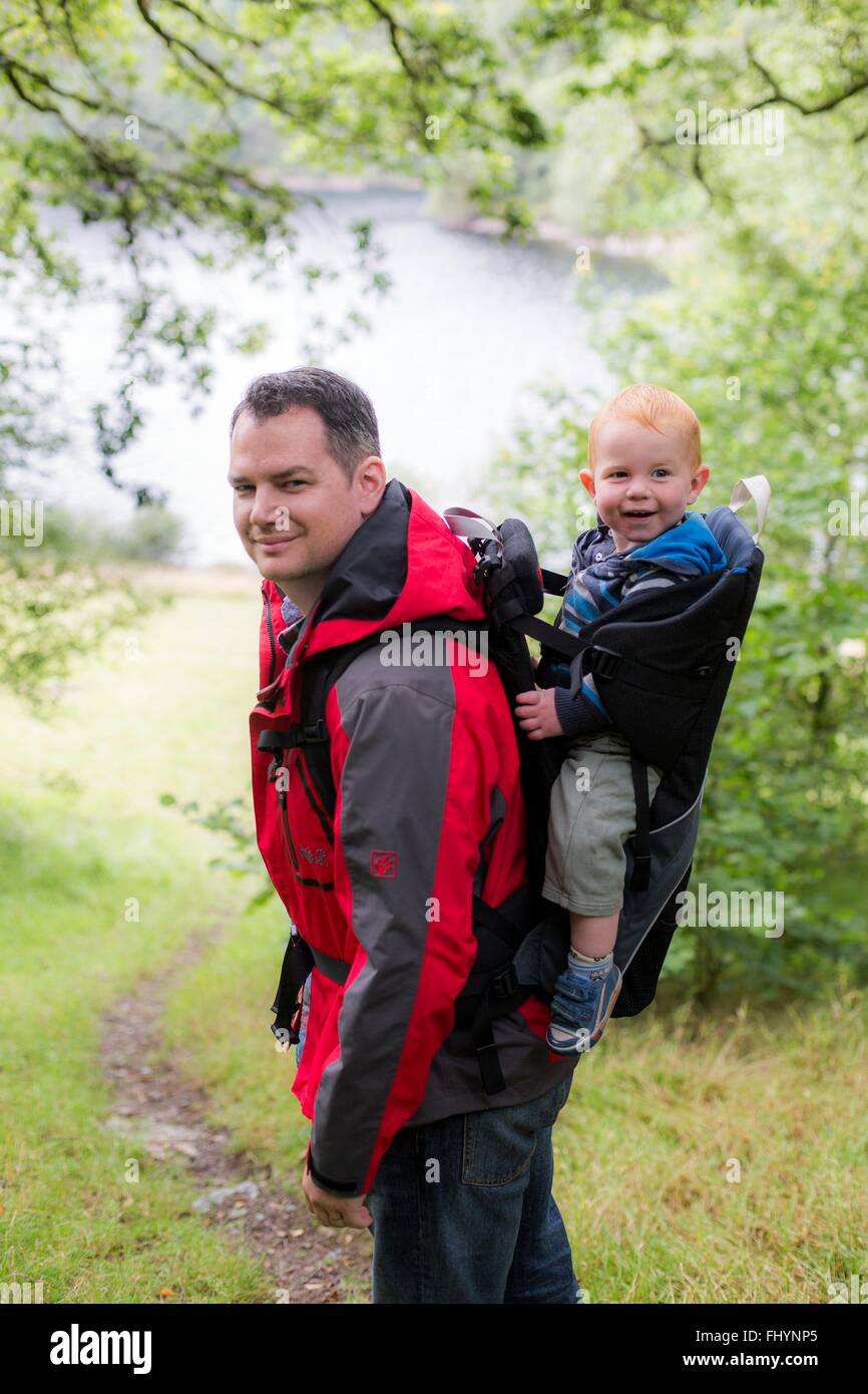 MODEL RELEASED. Father carrying his son in a back carrier. Stock Photo