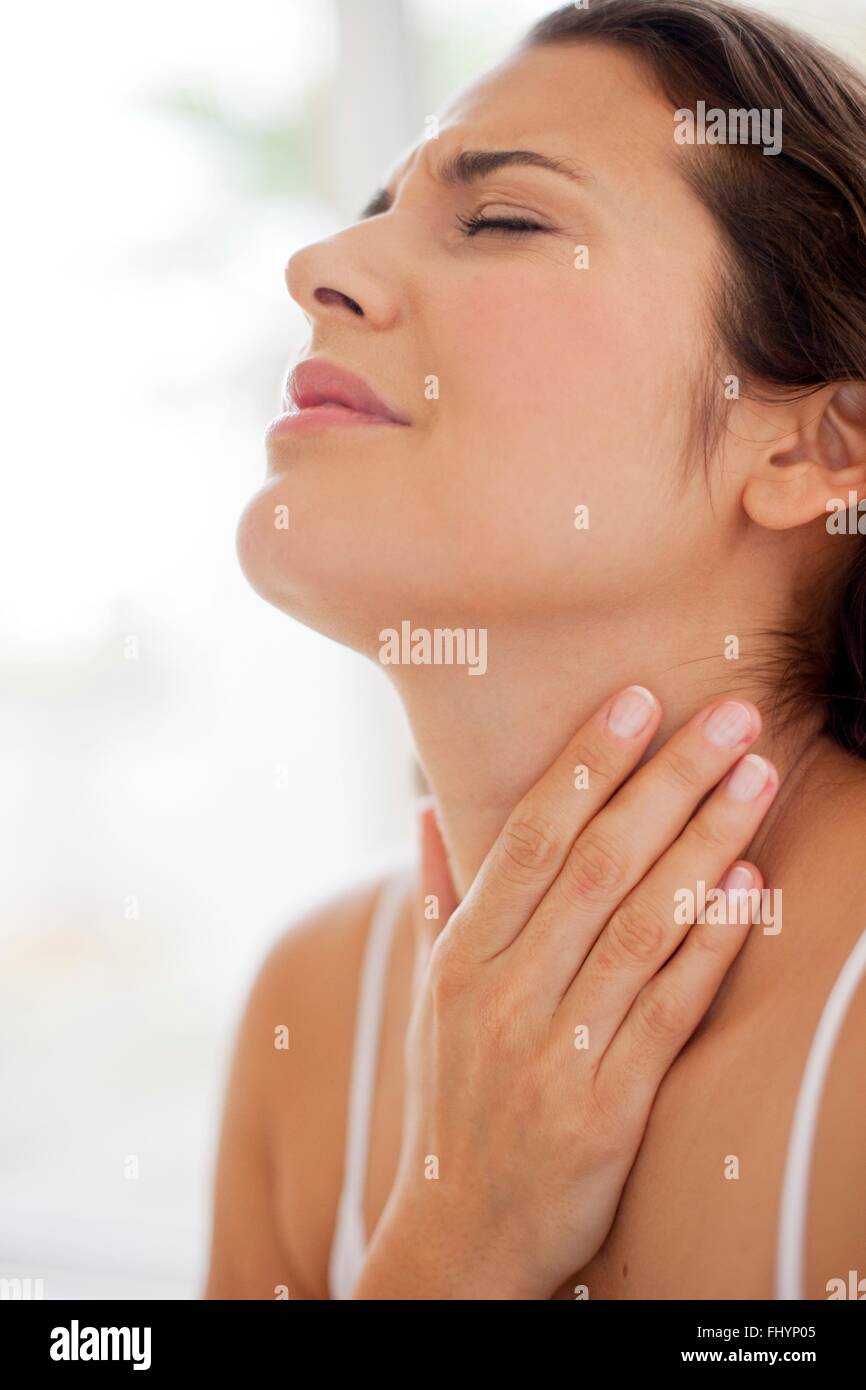MODEL RELEASED. Woman with her hand on her throat in pain. Stock Photo