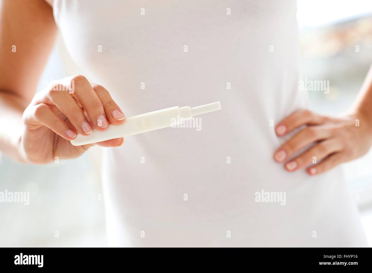 MODEL RELEASED. Woman taking a pregnancy test. Stock Photo