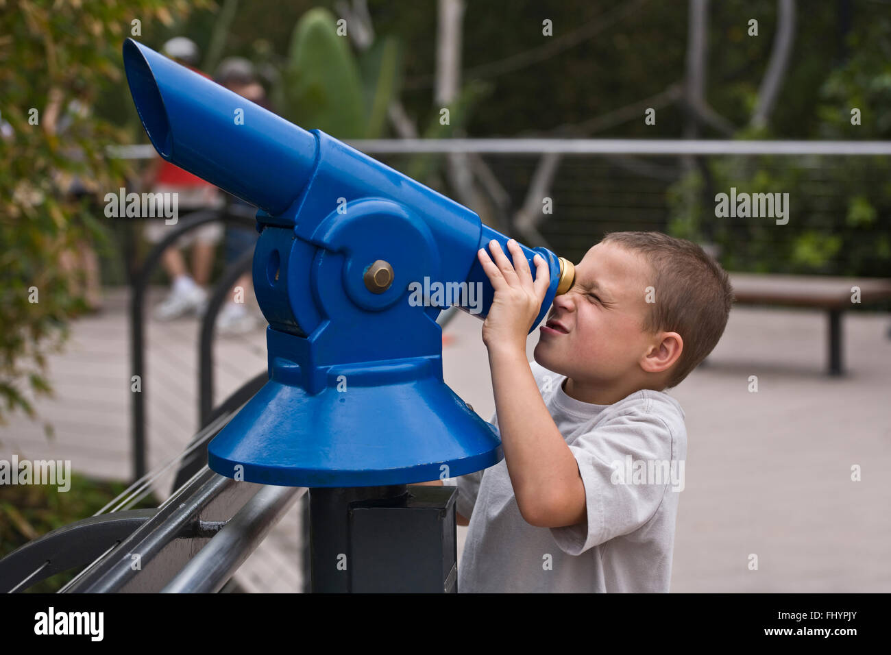 A young boy uses a telescope at the SAN DIEGO ZOO - CALIFORNIA Stock Photo