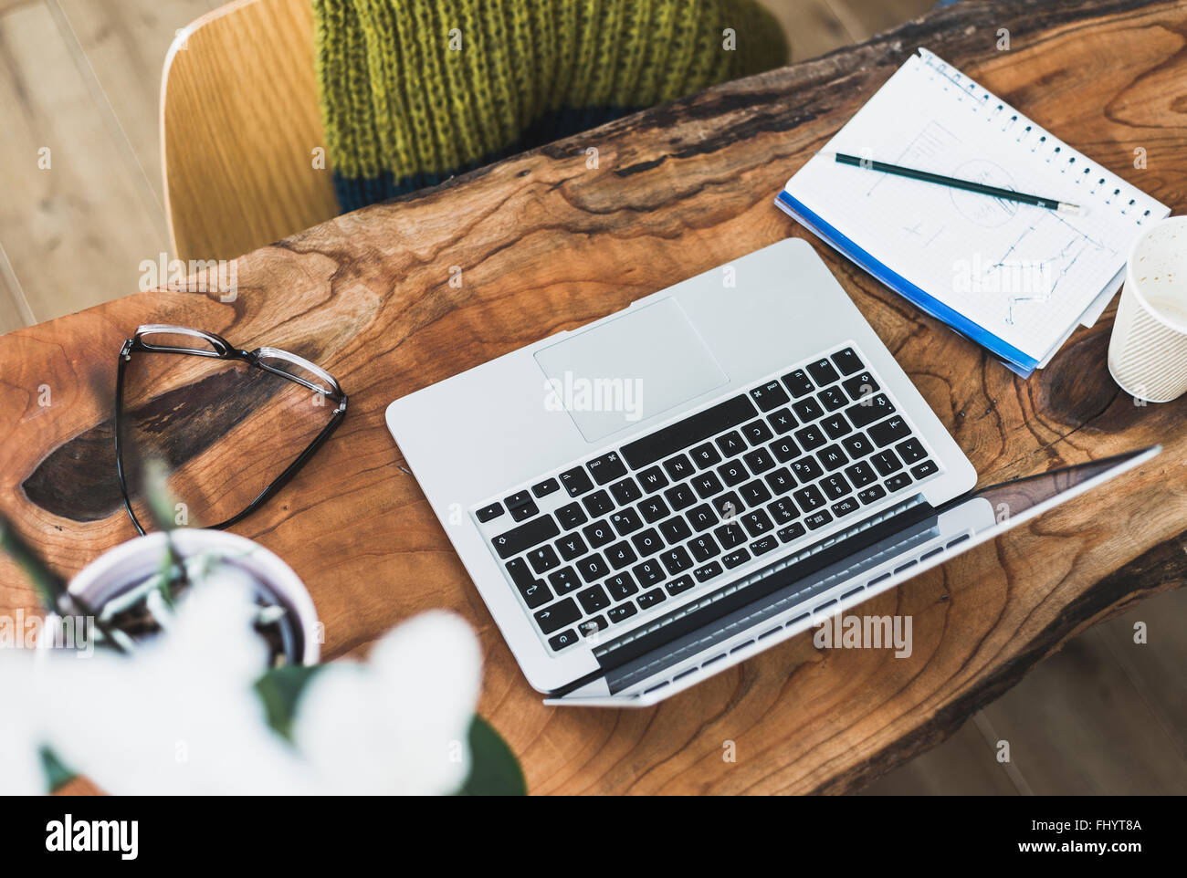 Laptop, notepad and glasses on wooden desk Stock Photo