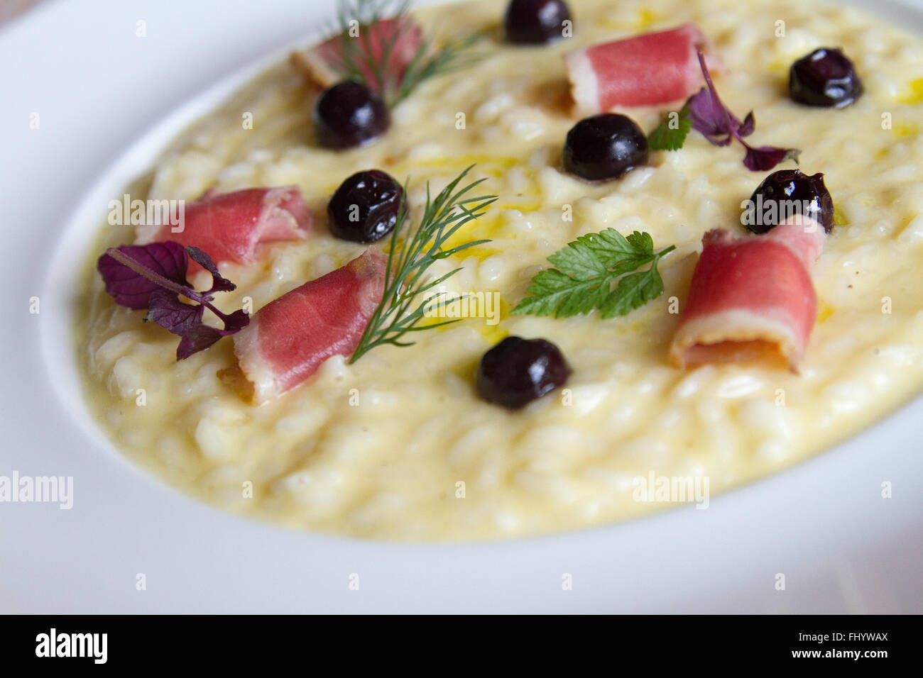 Risotto with olives and cured meats Stock Photo