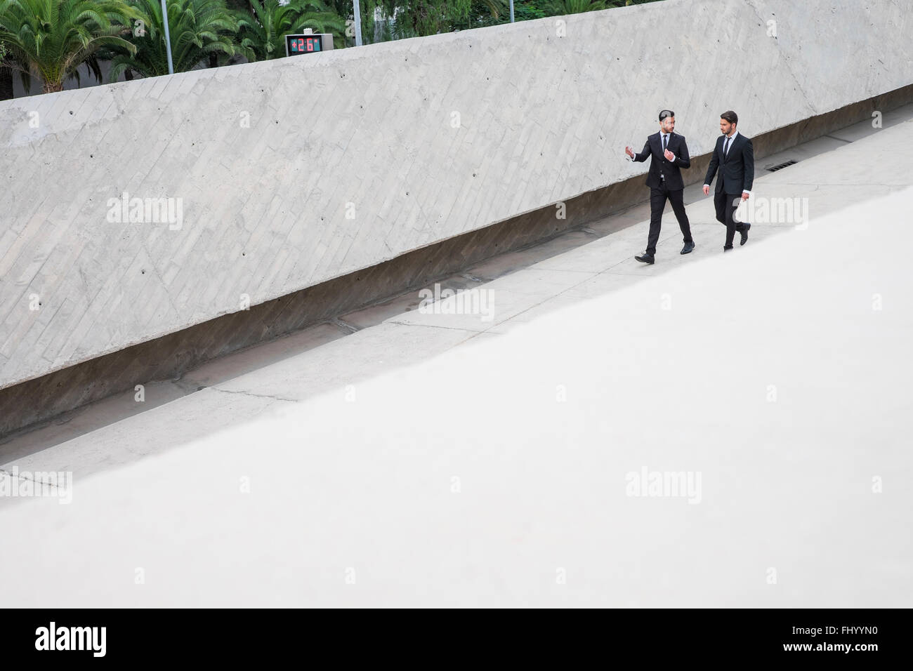Two businessmen wearing black suits communicating Stock Photo - Alamy