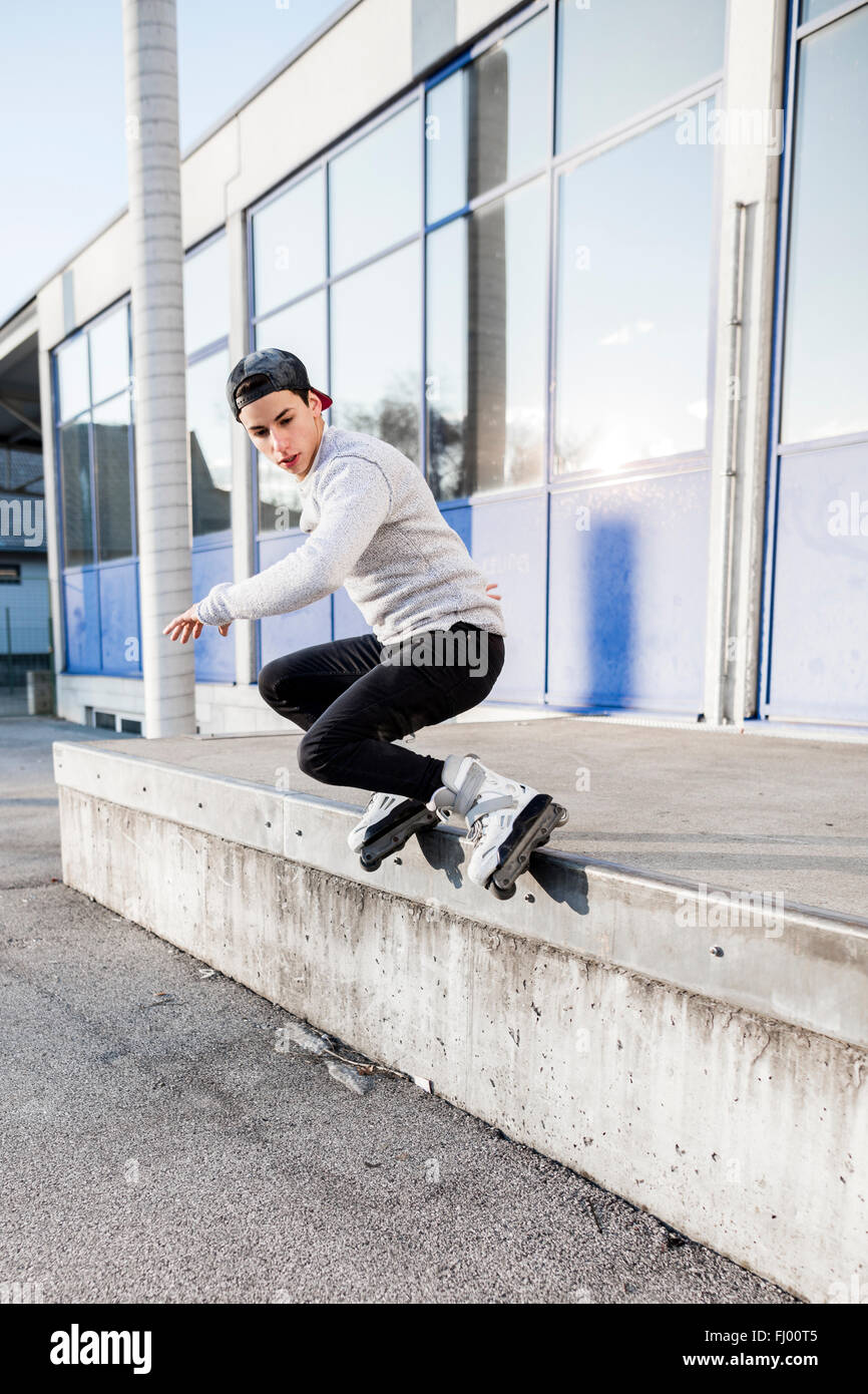 Young man doing a trick on inline skates Stock Photo