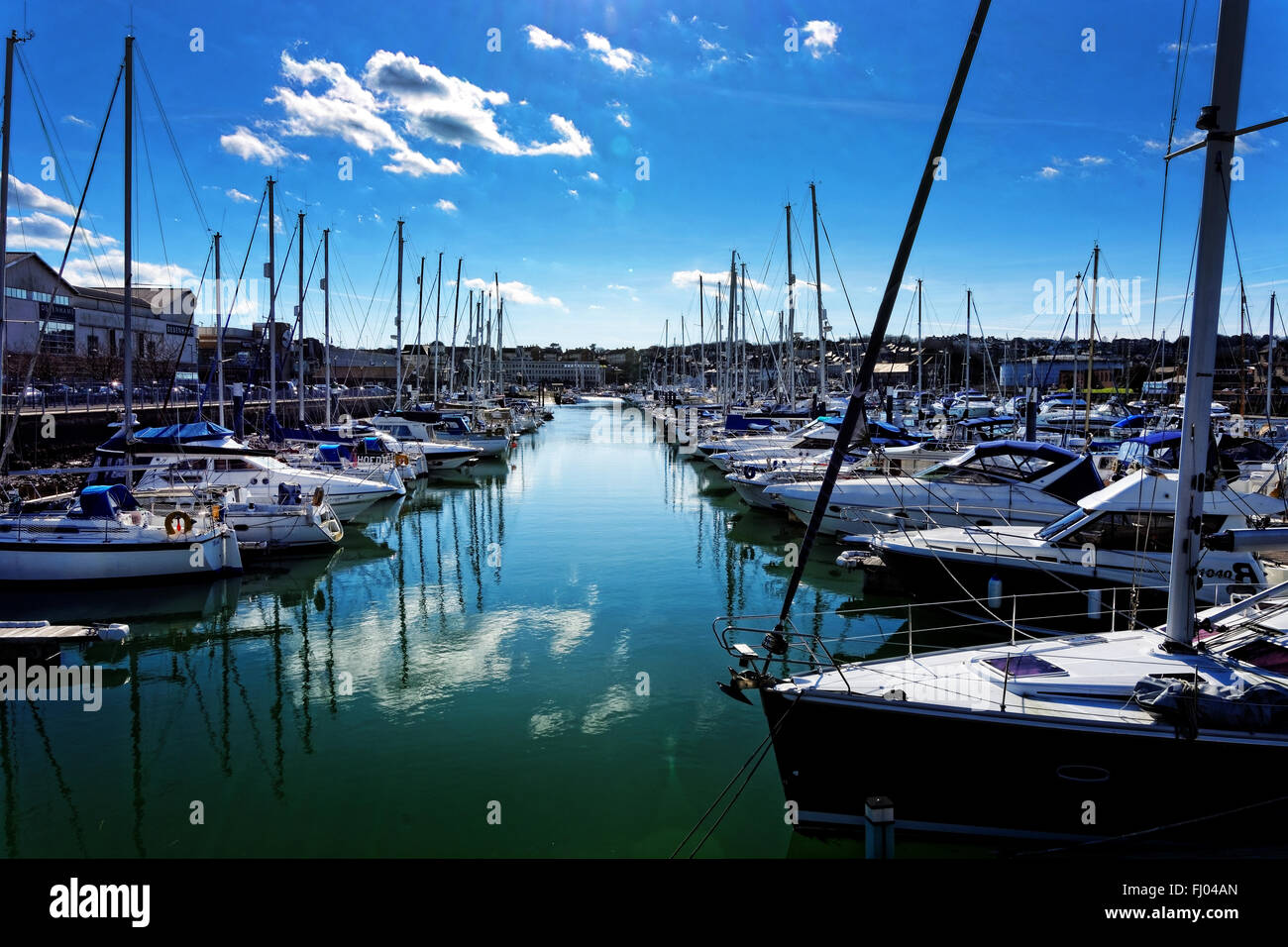 Boats moored at Weymouth marina, UK, in bright sunshine, the town being on the far side Stock Photo