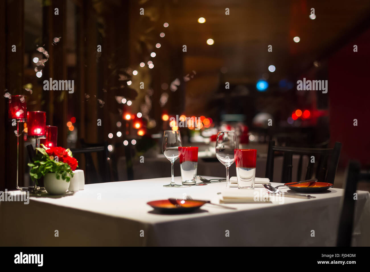 romantic dinner setup, red decoration with candle light in a restaurant. Selective focus. Stock Photo