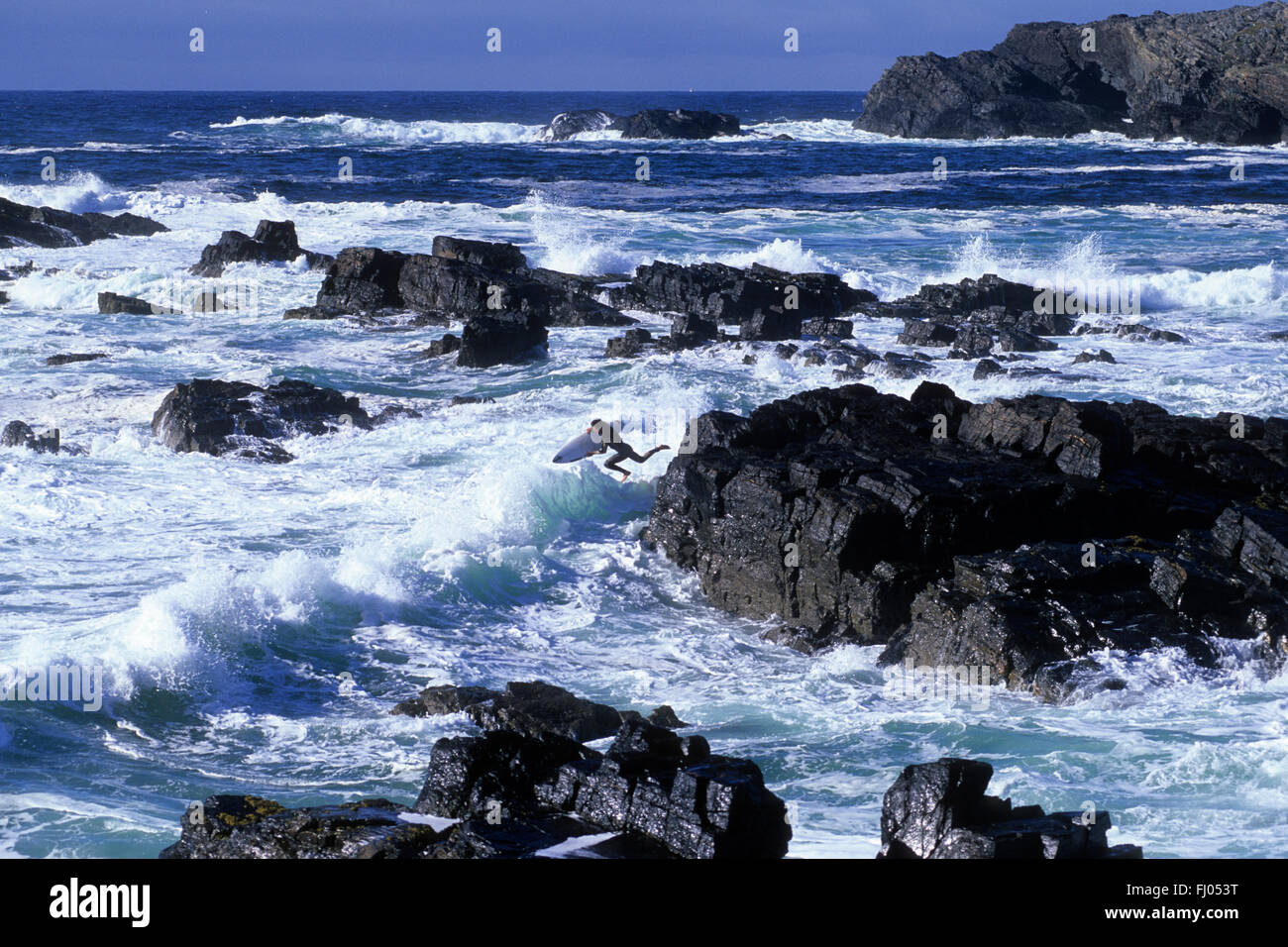 Surfer leaps into the frothing surf at Europie in the Outer Hebrides