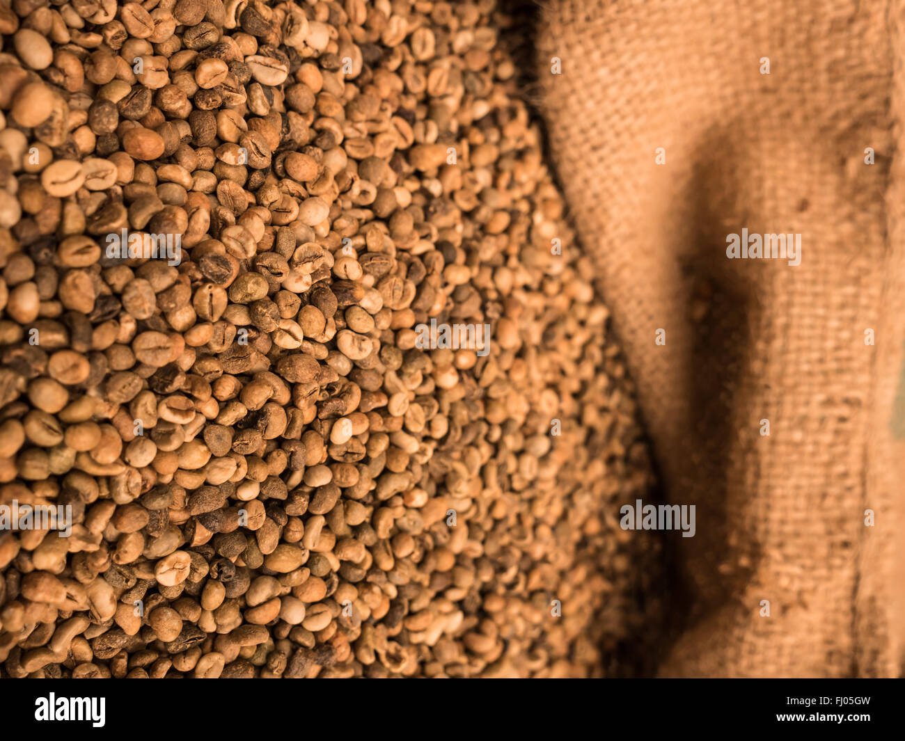 green unroasted coffee beans in sack Stock Photo - Alamy