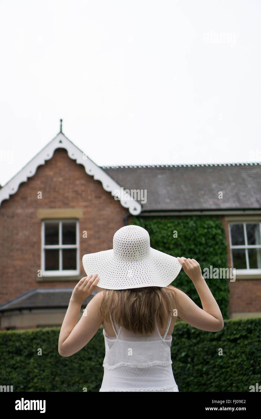 Woman in hat outside the house Stock Photo