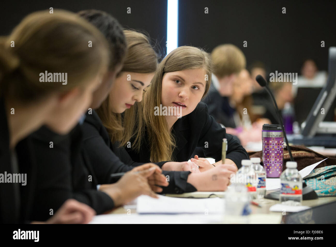 Teens posing as defense attorneys in mock trial for high school students discuss proceedings in county courtroom in Texas Stock Photo