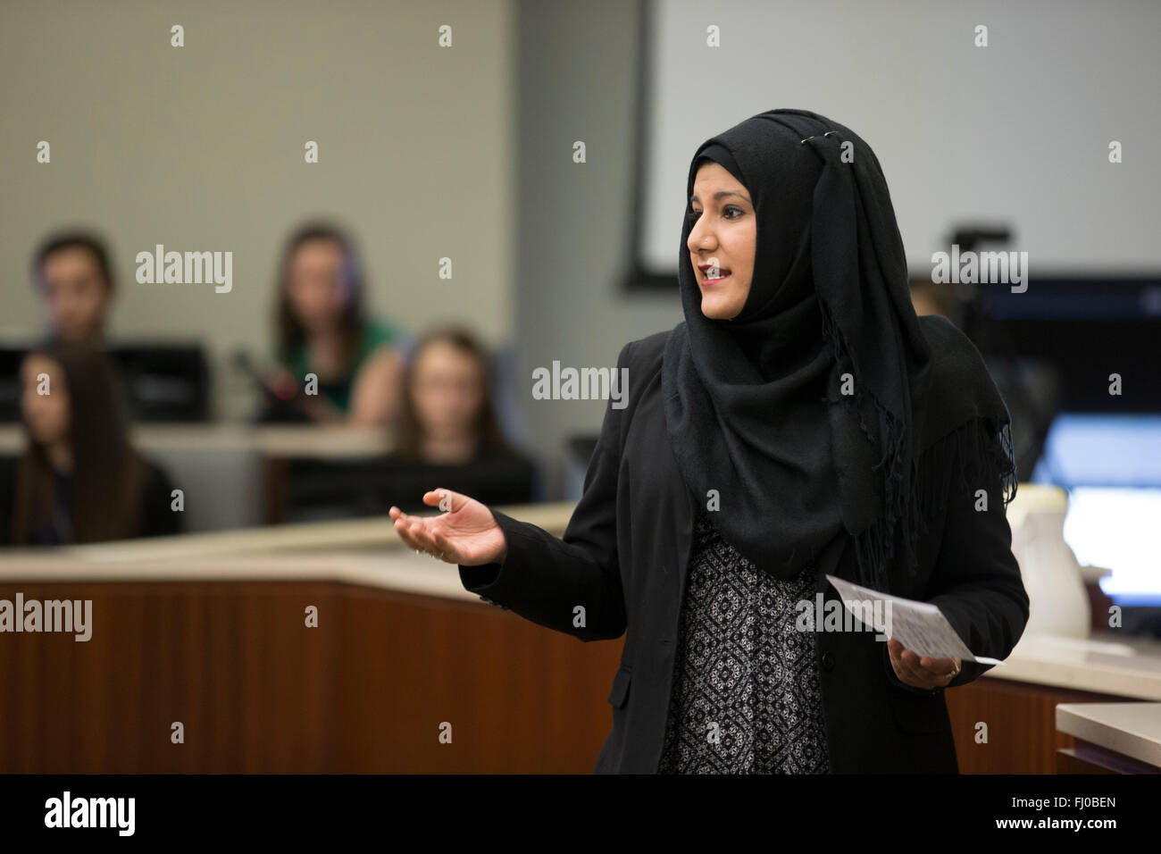Muslim teen girl in hijab posing as prosecuting attorney presents case
