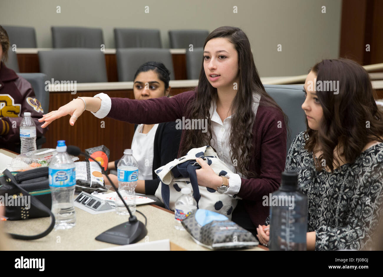 Teen girl serving on defense team during mock trial makes a point during deliberations in court room in San Marcos Texas Stock Photo
