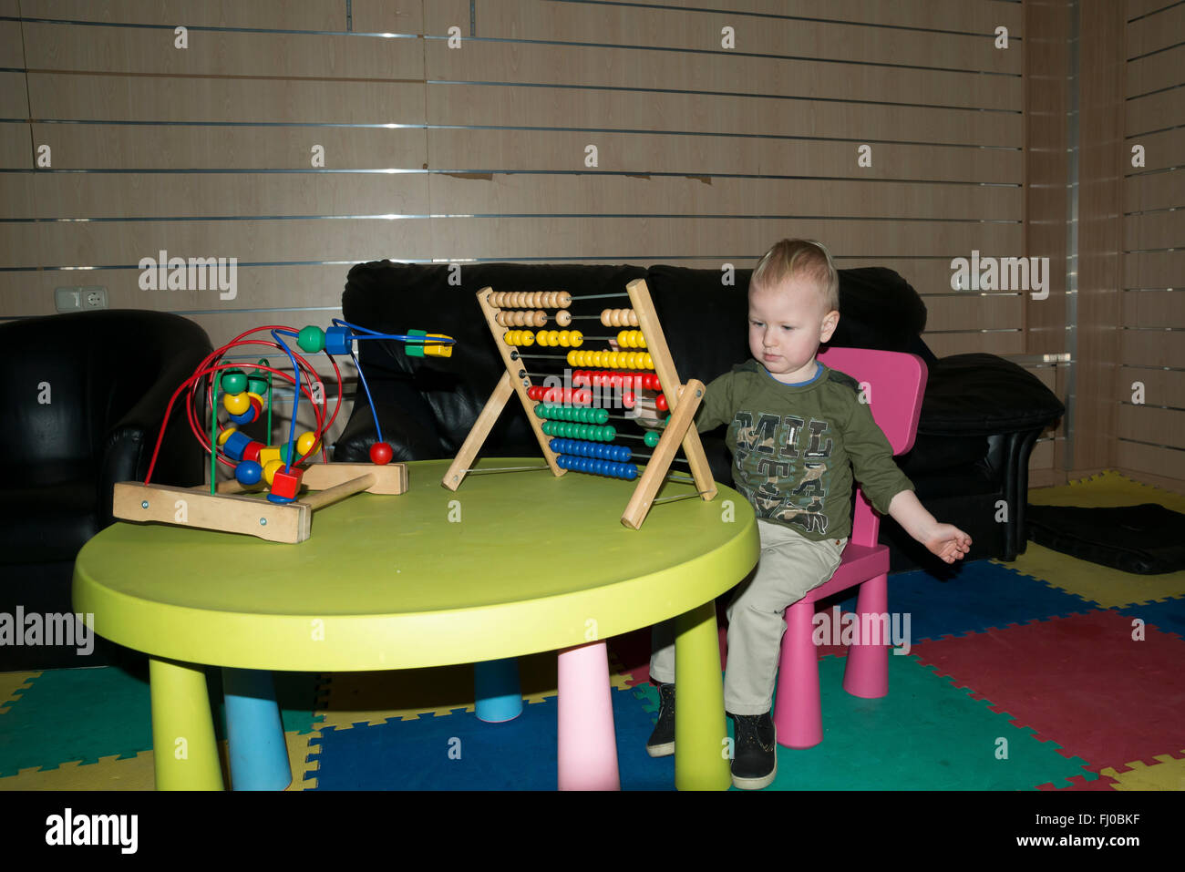 2 year old boy playing with abacus Stock Photo