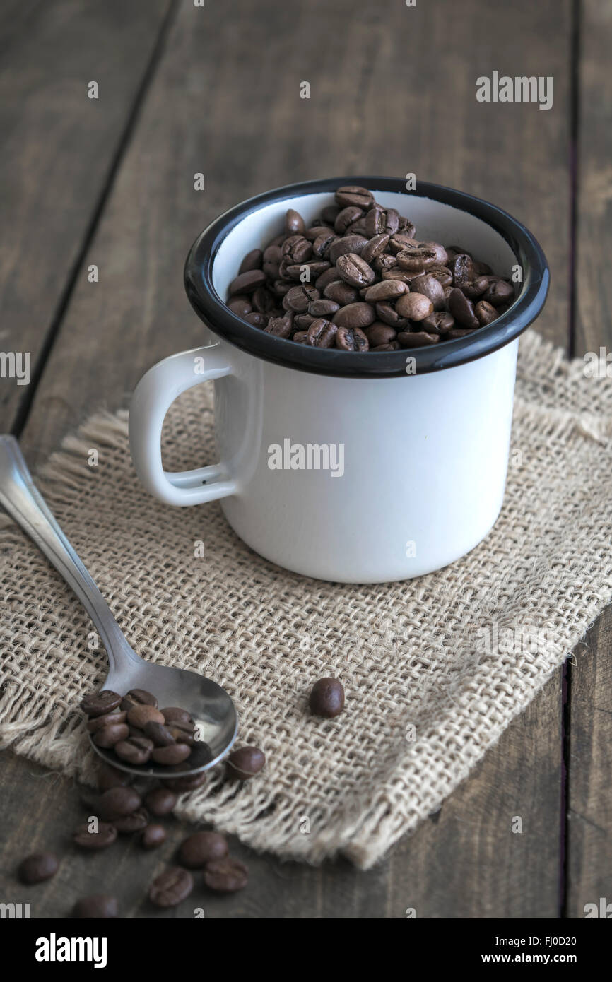 Coffee beans in an enamel mug on the wooden background Stock Photo