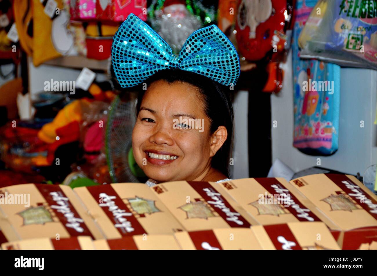 Ayutthaya, Thailand:  Smiling woman with large blue hair bow selling souvenirs at the Ayutthaya Floating Market Stock Photo