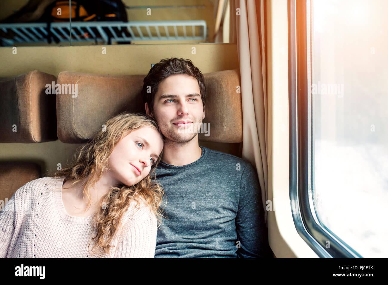 Smiling young couple in train car looking out of window Stock Photo Alamy