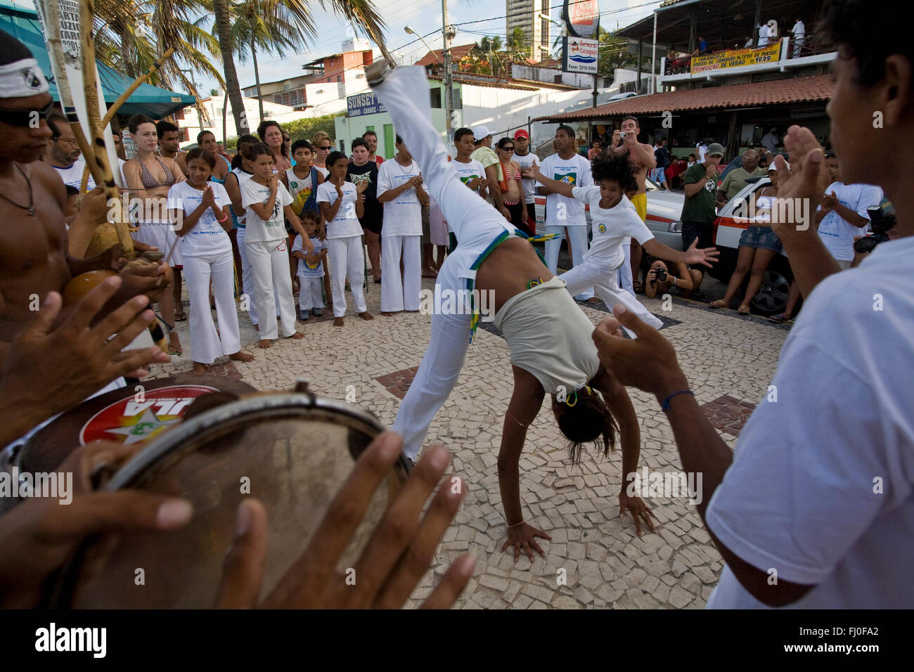 Capoeira, a Brazilian martial art that combines elements of dance, acrobatics and music, and is usually referred to as a game - known for quick and complex moves, using mainly power, speed, and leverage for a wide variety of kicks, spins, and highly mobile techniques - The Roda de capoeira is a circle formed by capoeiristas and capoeira musical instruments, where every participant sings the typical songs and claps their hands following the music - two capoeiristas enter the roda and play the game according to the style required by the musical instruments rhythm. Stock Photo